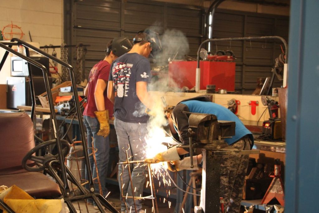 A student welding in the industrial arts shop
