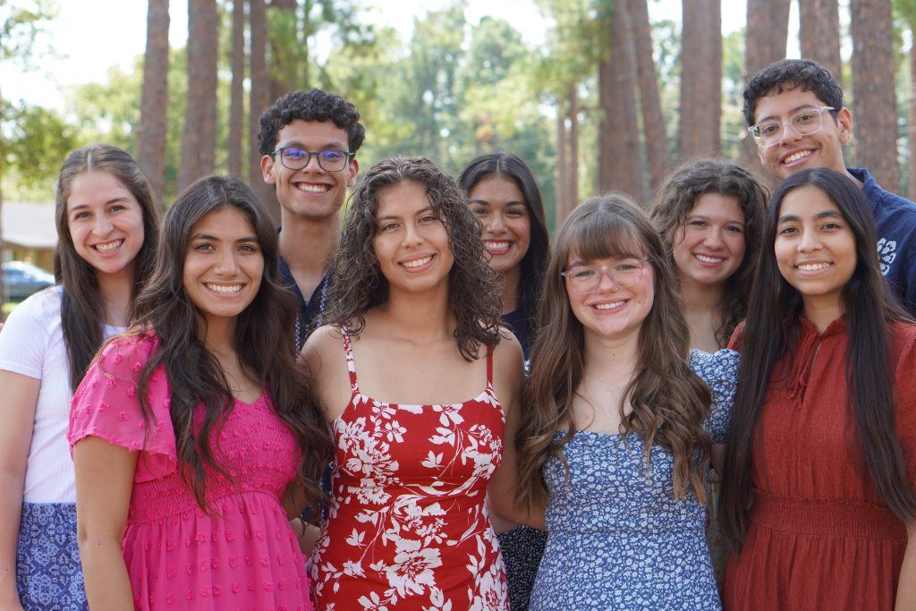 A group of CTA students outdoors among tall pines
